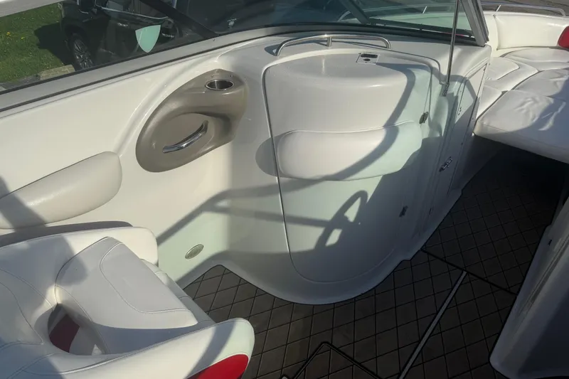 Slide: The Image of 2005 Crownline 270 BR boat interior with white seating and storage compartments. - 11