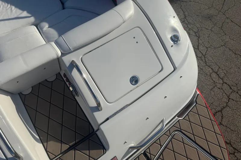 Slide: The Image of 2005 Crownline 270 BR boat interior with white seating and storage compartment. - 14
