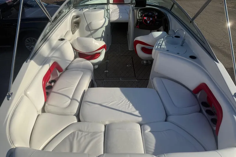 Slide: The Image of 2005 Crownline 270 BR boat interior with white and red seating, steering console, and cup holders. - 5