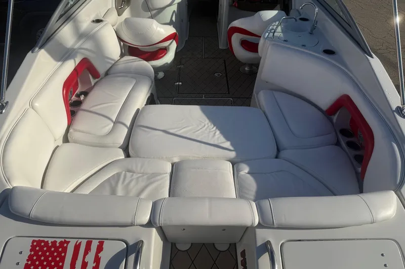 Slide: The Image of 2005 Crownline 270 BR boat interior with white and red seating, cup holders, and sunlit upholstery. - 7