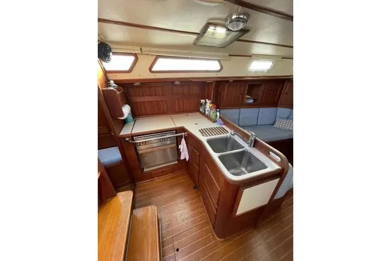 Slide: The Image of Interior of 1990 Sabre 38 sailboat featuring a wooden galley with dual sinks. - 10