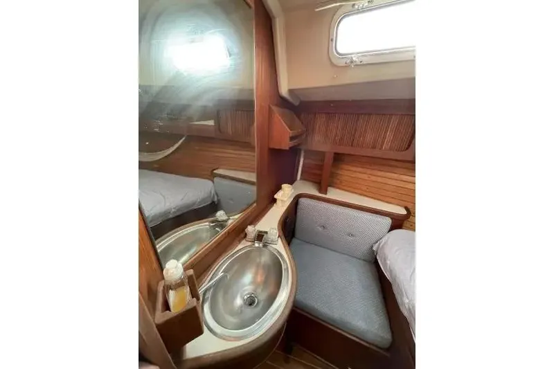 Slide: The Image of Interior of 1990 Sabre 38 sailboat featuring a compact sink and seating area. - 16