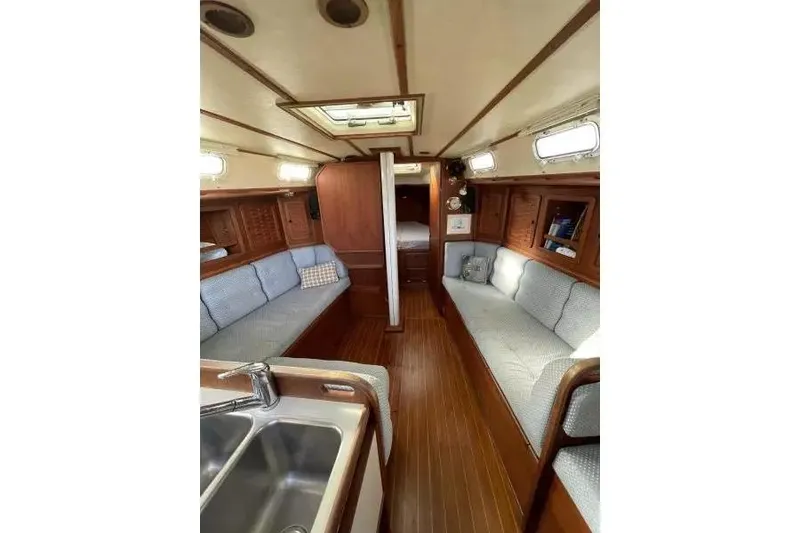 Slide: The Image of Interior of a 1990 Sabre 38 sailboat with wooden finishes and cozy seating. - 8