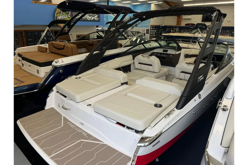 Slide: The Image of 2024 Regal LS2 boat with luxurious seating and sleek design in showroom. - 2