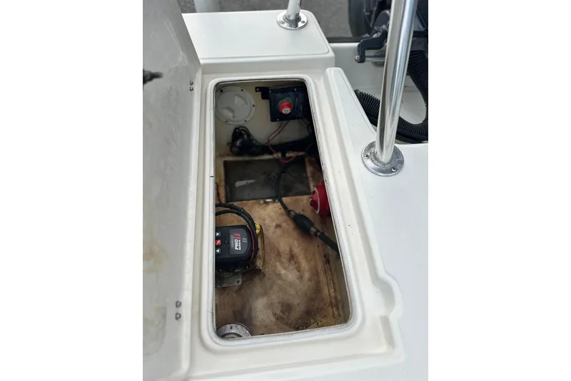 Slide: The Image of 2008 Hewes Redfisher 18 boat compartment with wiring and battery components. - 8