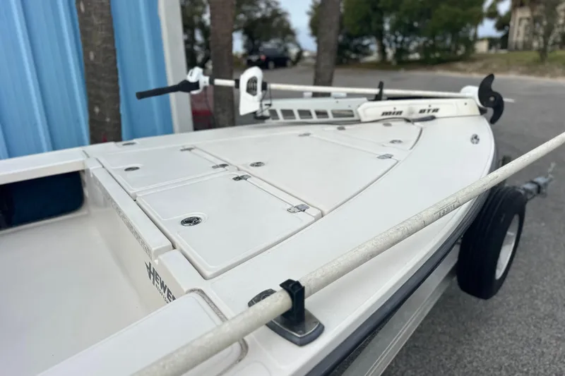 Slide: The Image of 2008 Hewes Redfisher 18 boat with white deck and trolling motor, parked outdoors. - 9