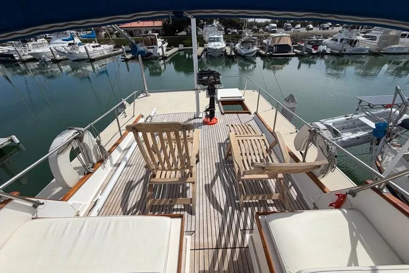 Slide: The Image of 1979 Grand Banks 42 Europa yacht deck with wooden chairs, marina view. - 13