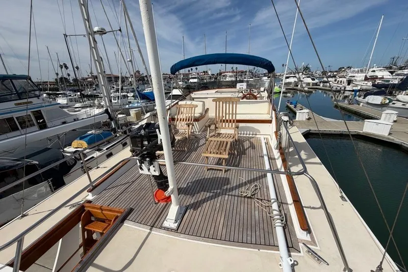 Slide: The Image of 1979 Grand Banks 42 Europa yacht docked at marina, featuring spacious deck and seating. - 14
