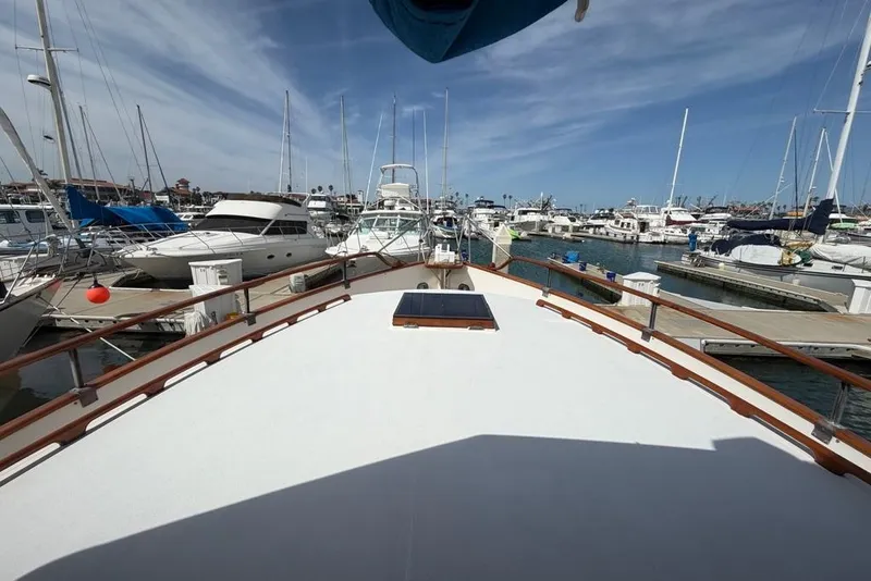 Slide: The Image of 1979 Grand Banks 42 Europa yacht docked in a bustling marina under a clear blue sky. - 17