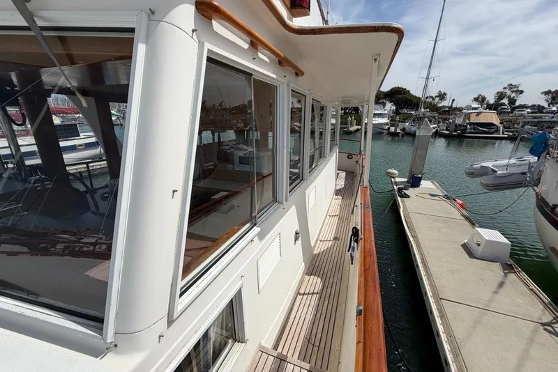 Slide: The Image of 1979 Grand Banks 42 Europa yacht docked at marina, showcasing side deck and windows. - 19