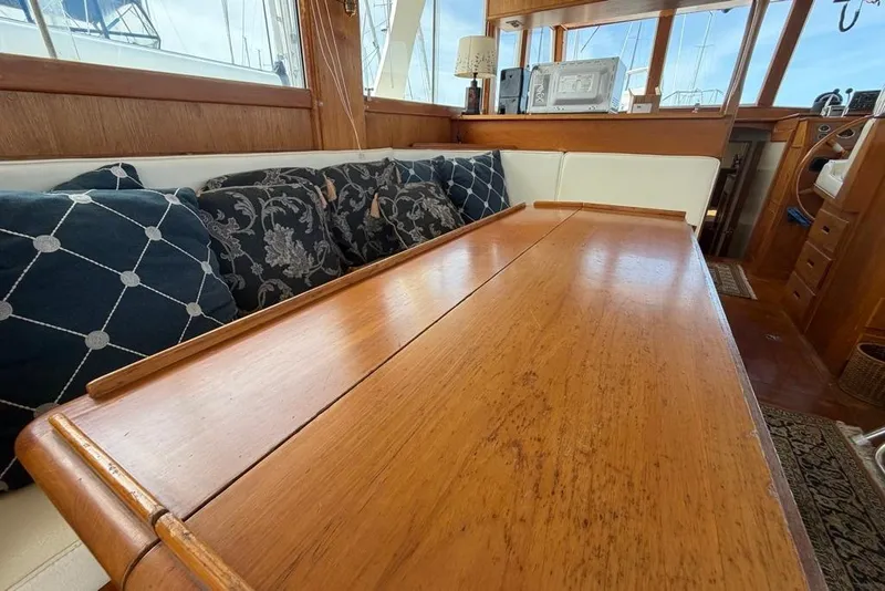 Slide: The Image of Interior of 1979 Grand Banks 42 Europa with wooden table and decorative cushions. - 27