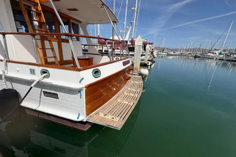 Slide: The Image of 1979 Grand Banks 42 Europa yacht docked in a marina, showcasing classic wooden design. - 3