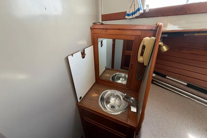 Slide: The Image of 1979 Grand Banks 42 Europa interior with wooden vanity, mirror, and stainless steel sink. - 31