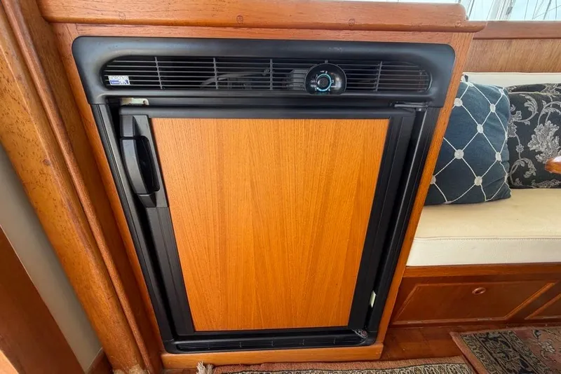Slide: The Image of Wood-paneled refrigerator on a 1979 Grand Banks 42 Europa yacht interior. - 37