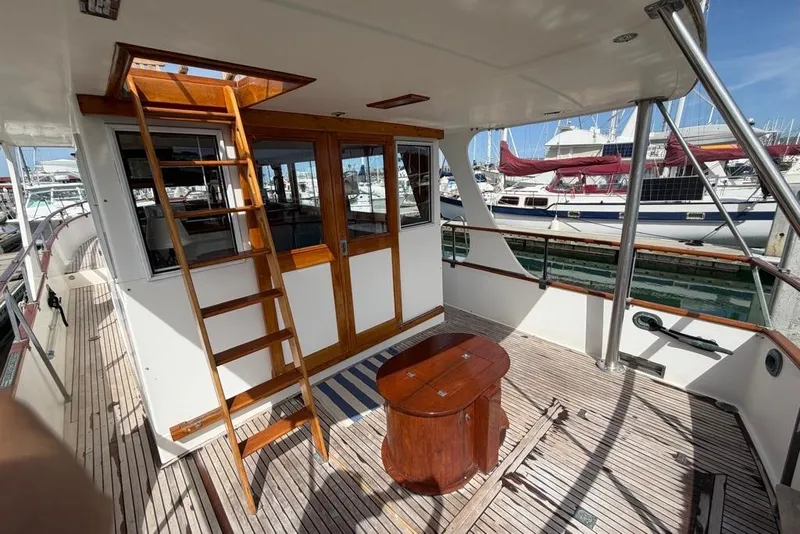 Slide: The Image of 1979 Grand Banks 42 Europa yacht deck with wooden ladder and table, docked at marina. - 4
