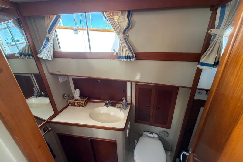 Slide: The Image of 1979 Grand Banks 42 Europa yacht bathroom with sink, toilet, and wooden cabinetry. - 40