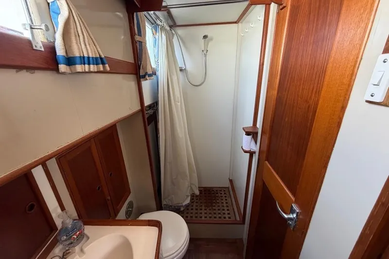 Slide: The Image of 1979 Grand Banks 42 Europa bathroom with wooden accents, shower, and sink. - 41