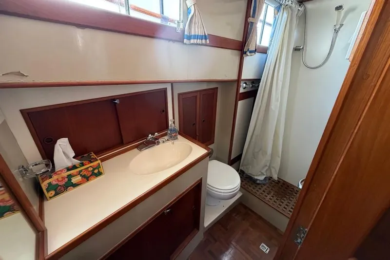 Slide: The Image of 1979 Grand Banks 42 Europa yacht bathroom with sink, toilet, and shower area. - 42