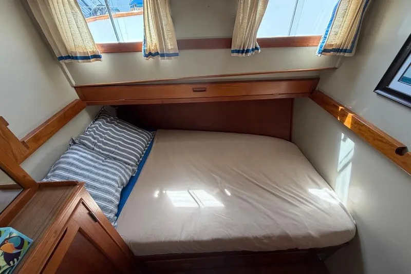 Slide: The Image of Cozy cabin interior of 1979 Grand Banks 42 Europa with bed and striped pillow. - 43