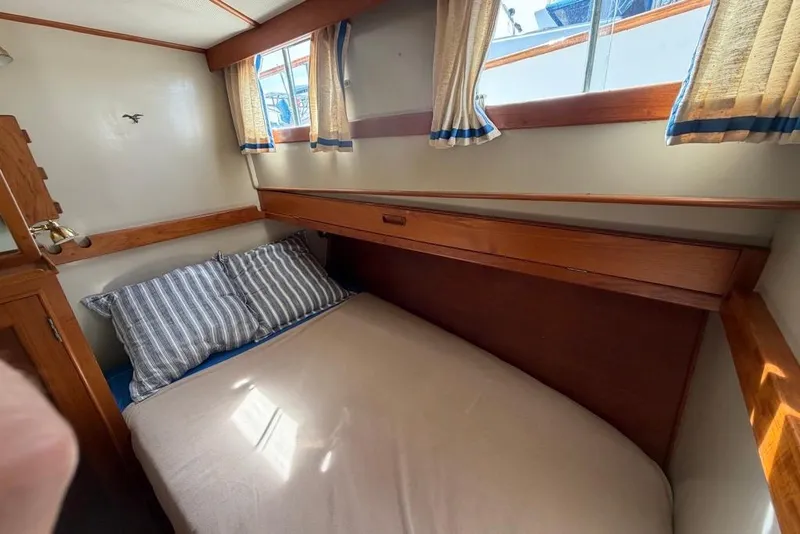 Slide: The Image of Cozy cabin interior of 1979 Grand Banks 42 Europa with striped pillows and wooden accents. - 44