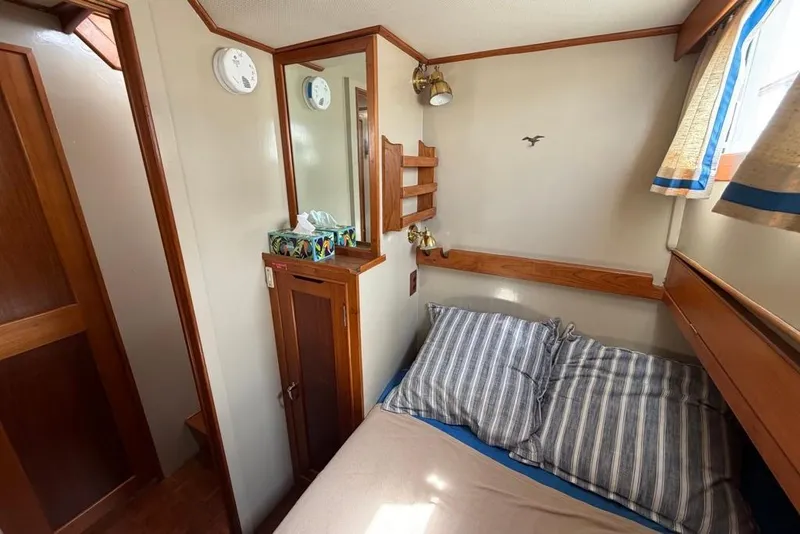 Slide: The Image of Cozy cabin interior of 1979 Grand Banks 42 Europa with striped bedding and wooden accents. - 47
