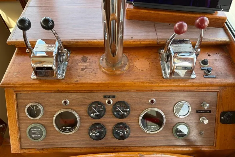 Slide: The Image of 1979 Grand Banks 42 Europa helm controls with gauges and throttle levers. - 49