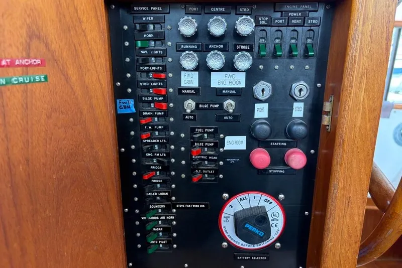 Slide: The Image of Control panel of a 1979 Grand Banks 42 Europa boat with various switches and dials. - 58