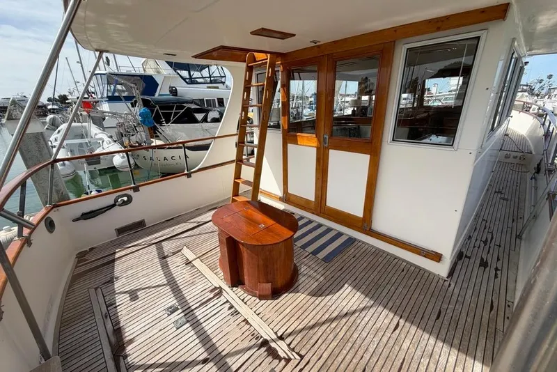 Slide: The Image of 1979 Grand Banks 42 Europa yacht deck with wooden doors and ladder in marina setting. - 6