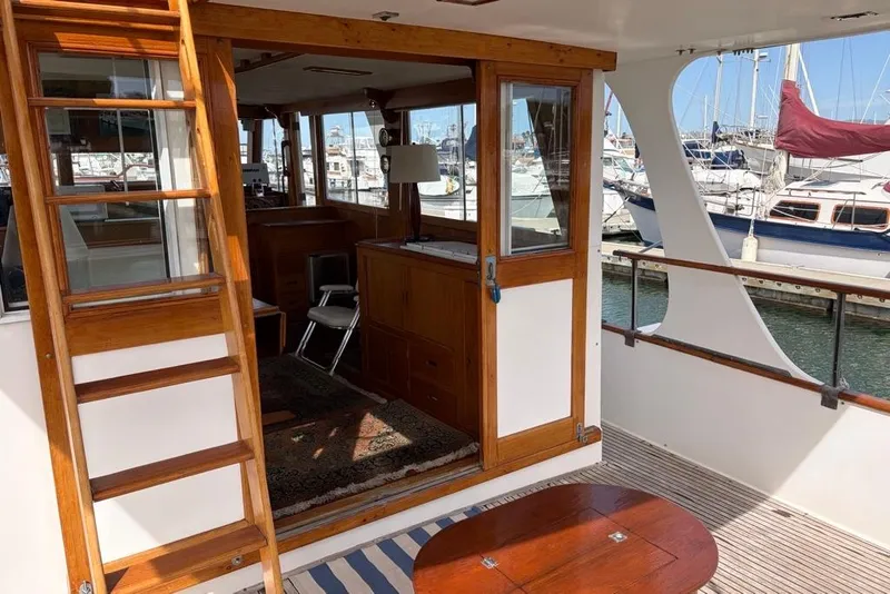 Slide: The Image of 1979 Grand Banks 42 Europa yacht interior with wooden accents and marina view. - 8