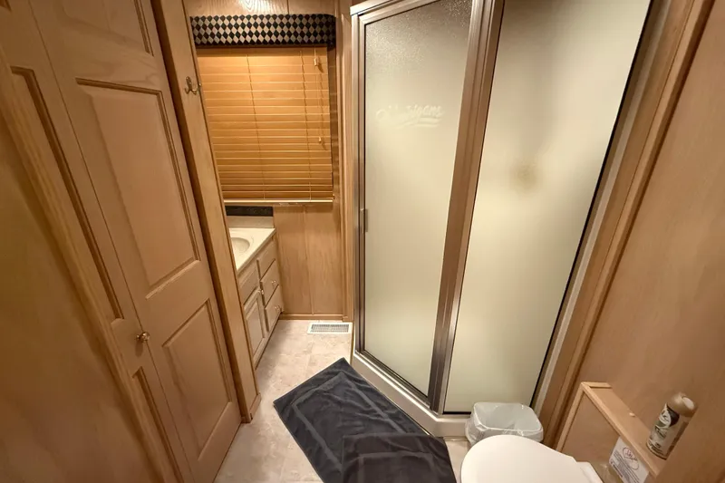 Slide: The Image of Bathroom interior of a 1998 Sumerset 16x76 houseboat with shower and wooden cabinetry. - 10