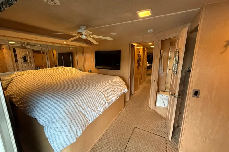 Slide: The Image of Bedroom interior of 1998 Sumerset 16x76 houseboat with striped bedding and ceiling fan. - 11