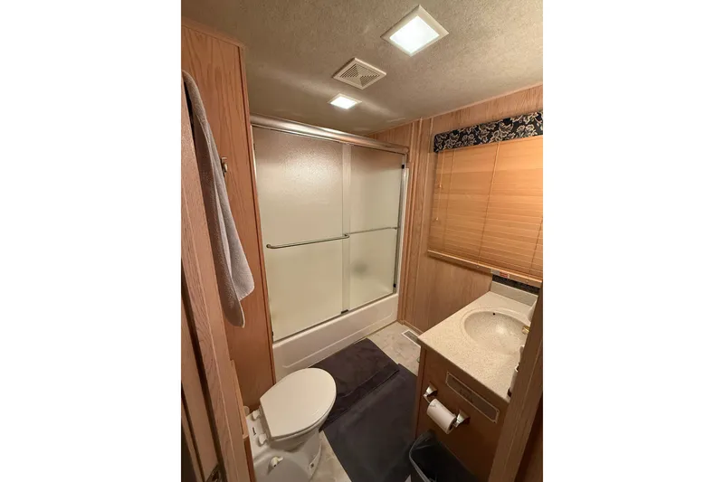 Slide: The Image of Bathroom interior of a 1998 Sumerset 16x76 houseboat with shower, toilet, and sink. - 12