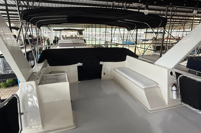 Slide: The Image of 1998 Sumerset 16x76 houseboat interior with seating and canopy in marina. - 13