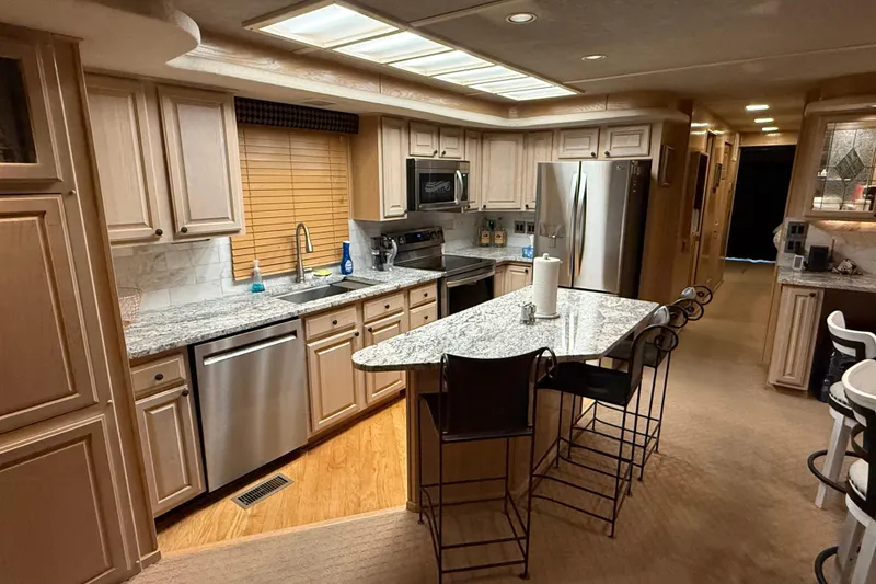 Slide: The Image of Luxurious kitchen interior of a 1998 Sumerset 16x76 houseboat with modern appliances and granite countertops. - 5