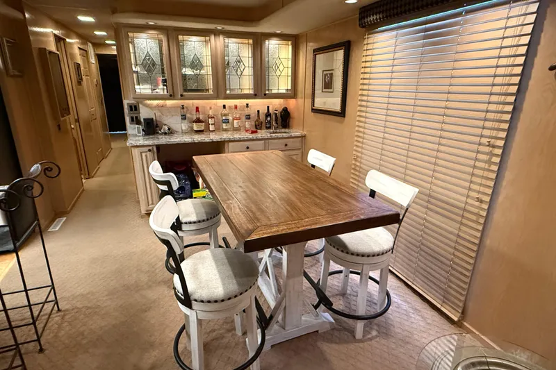 Slide: The Image of Interior of a 1998 Sumerset 16x76 houseboat with dining area and bar setup. - 6