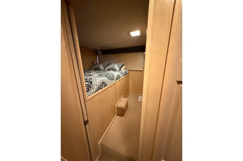 Slide: The Image of Cozy bedroom interior of 1998 Sumerset 16x76 houseboat with patterned bedding and wooden decor. - 7