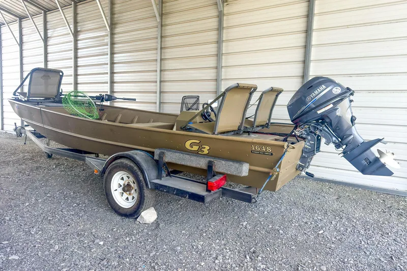 The Image of 2022 G3 1648 LW boat with Yamaha motor on trailer in covered storage. - 1