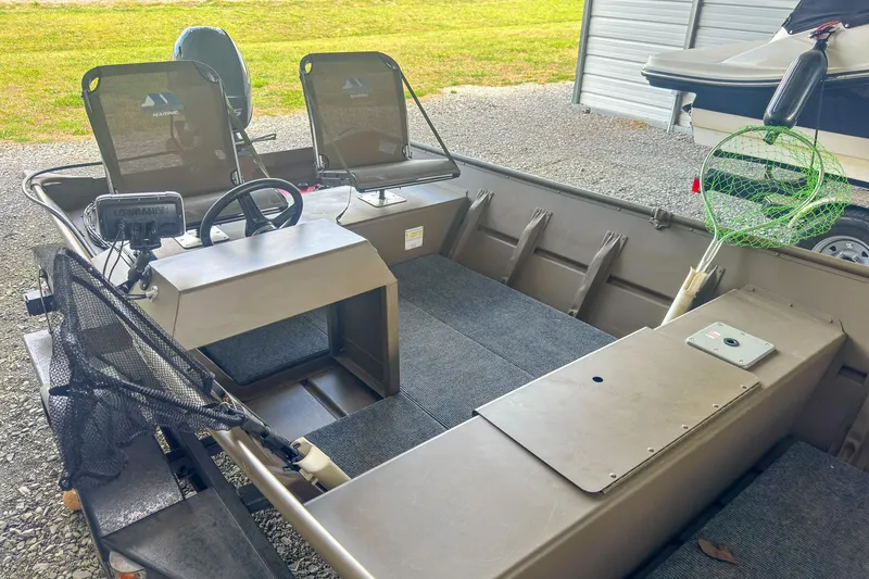 Slide: The Image of 2022 G3 1648 LW boat interior with seats, steering, and fishing gear. - 15