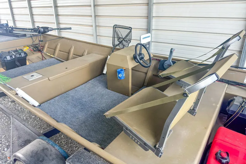 Slide: The Image of 2022 G3 1648 LW boat interior with steering wheel and seating in storage. - 19
