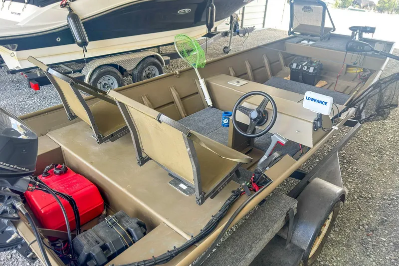 Slide: The Image of 2022 G3 1648 LW boat interior with steering wheel, seats, and fishing equipment. - 9