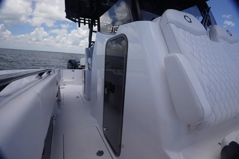 Slide: The Image of 2023 Fountain 38 Tournament Edition boat interior with white seating and ocean view. - 20