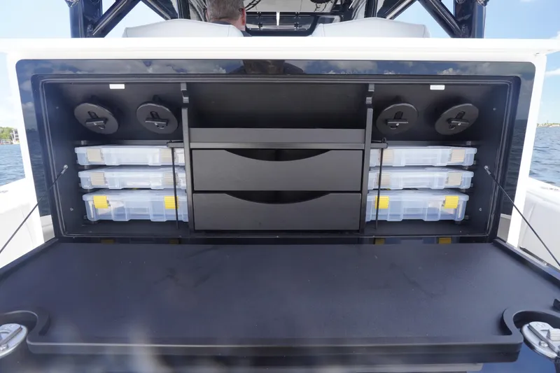 Slide: The Image of Storage compartment on a 2023 Fountain 38 Tournament Edition boat, featuring organized tackle boxes. - 39