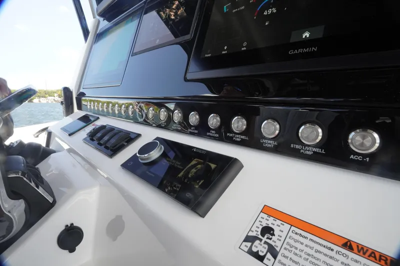 Slide: The Image of Control panel of 2023 Fountain 38 Tournament Edition boat with Garmin display and switches. - 53