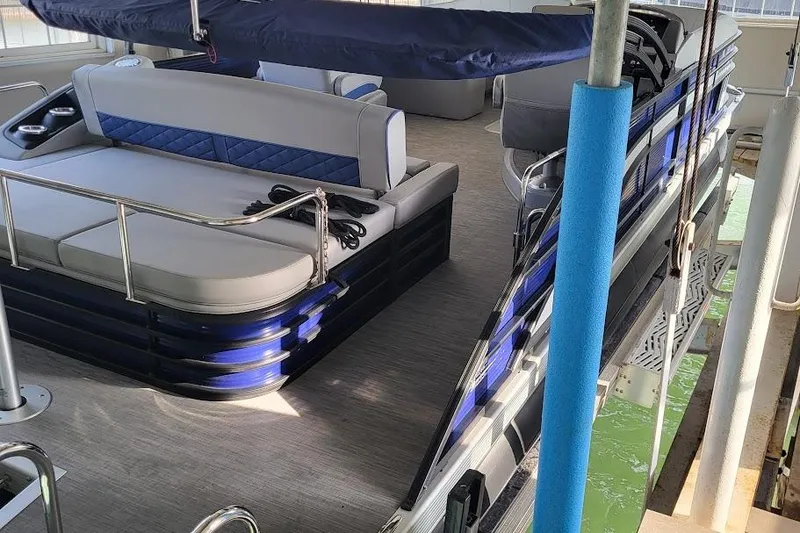 The Image of 2023 Bennington L 25 Swingback pontoon boat interior with blue accents and seating. - 0