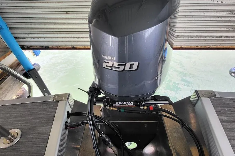 Slide: The Image of Yamaha 250 outboard motor on 2023 Bennington L 25 Swingback boat, docked by water. - 11