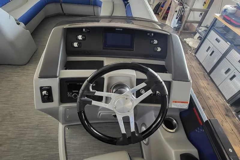 Slide: The Image of 2023 Bennington L 25 Swingback boat dashboard with steering wheel and controls. - 16
