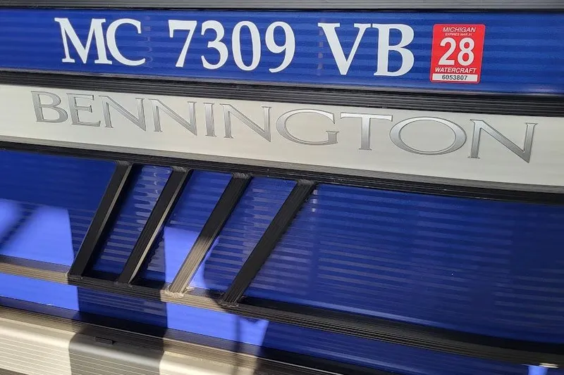 Slide: The Image of 2023 Bennington L 25 Swingback boat with Michigan registration sticker and model branding. - 20