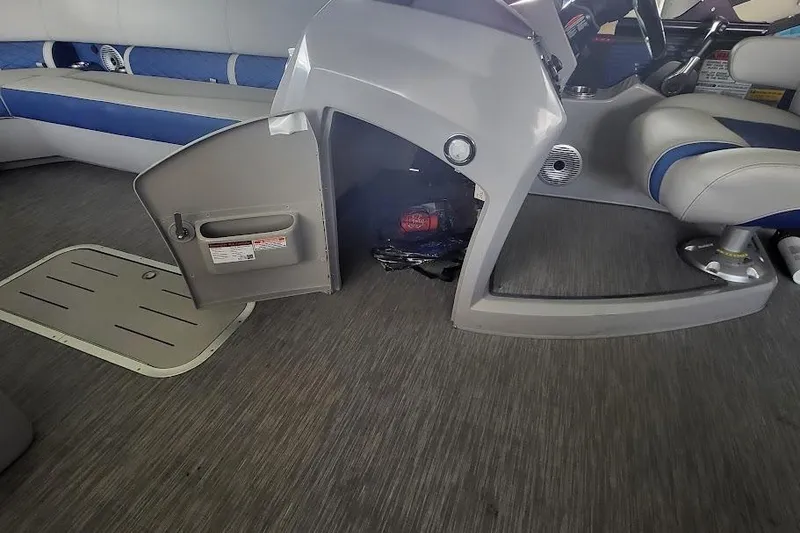 Slide: The Image of 2023 Bennington L 25 Swingback interior with open storage compartment and seating. - 9