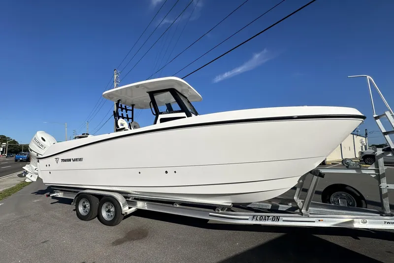Slide: The Image of 2026 Twin Vee 260 GFX2 CC boat on trailer under clear blue sky. - 2
