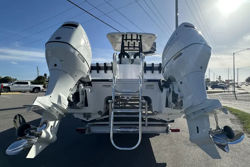 Slide: The Image of 2026 Twin Vee 260 GFX2 CC boat with dual outboard engines, parked on a sunny day. - 3